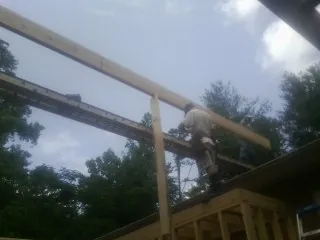 Carpenter setting a ridge beam over a new addition frame — Ice Dam Removal by Roofing Brothers in East Templeton