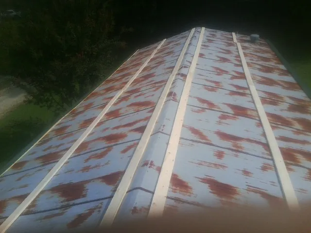 Rusted metal roof panels with new wood purlins before replacement — Storm Damage Roof Repair in East Templeton by Roofing Brothers