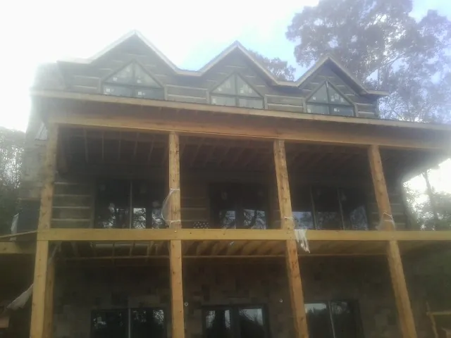 Dormers and porch framing on a large log home under construction — Roof Coating work by our crew in East Templeton