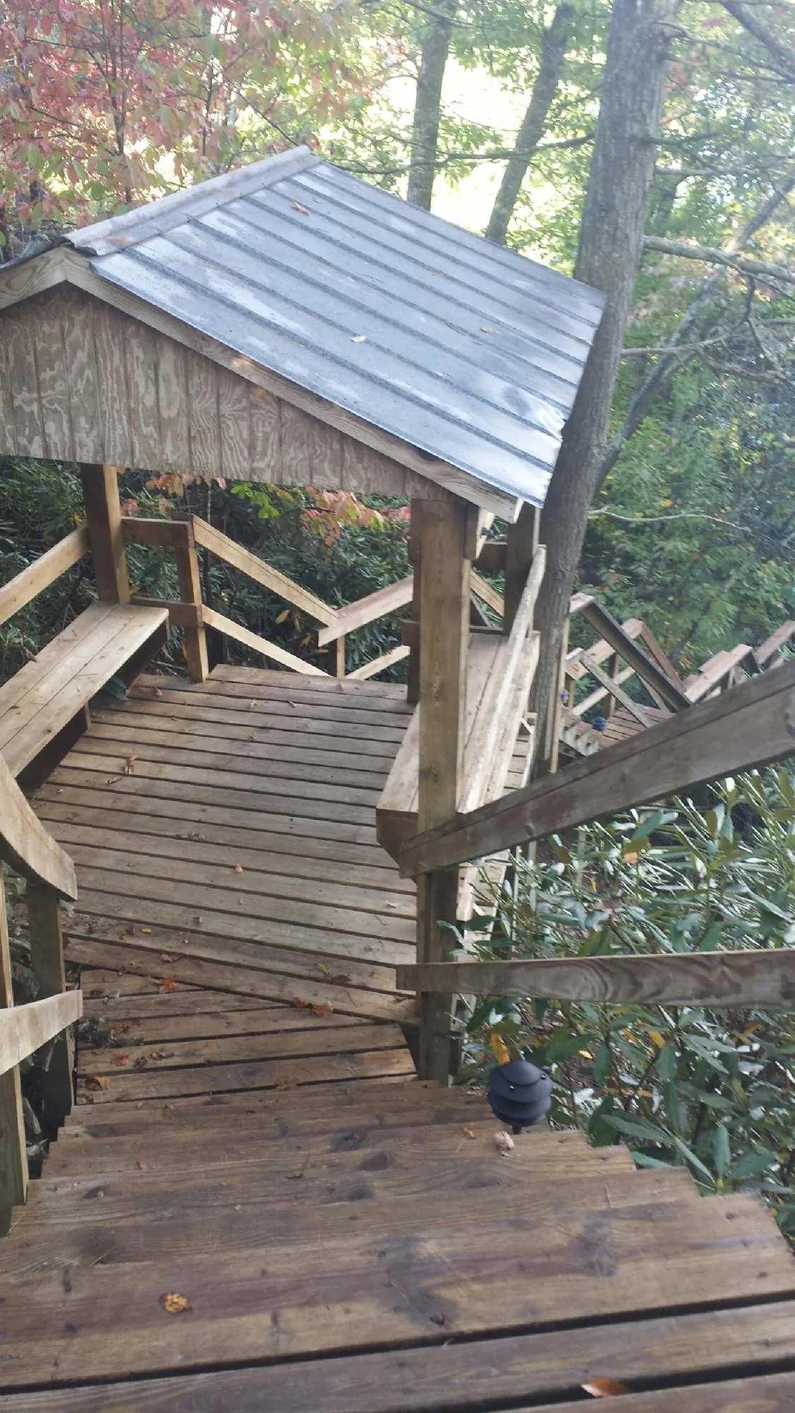 Metal roofed shelter over wooden steps on a wooded walkway — Skylight Repair & Installation work by our crew in East Templeton