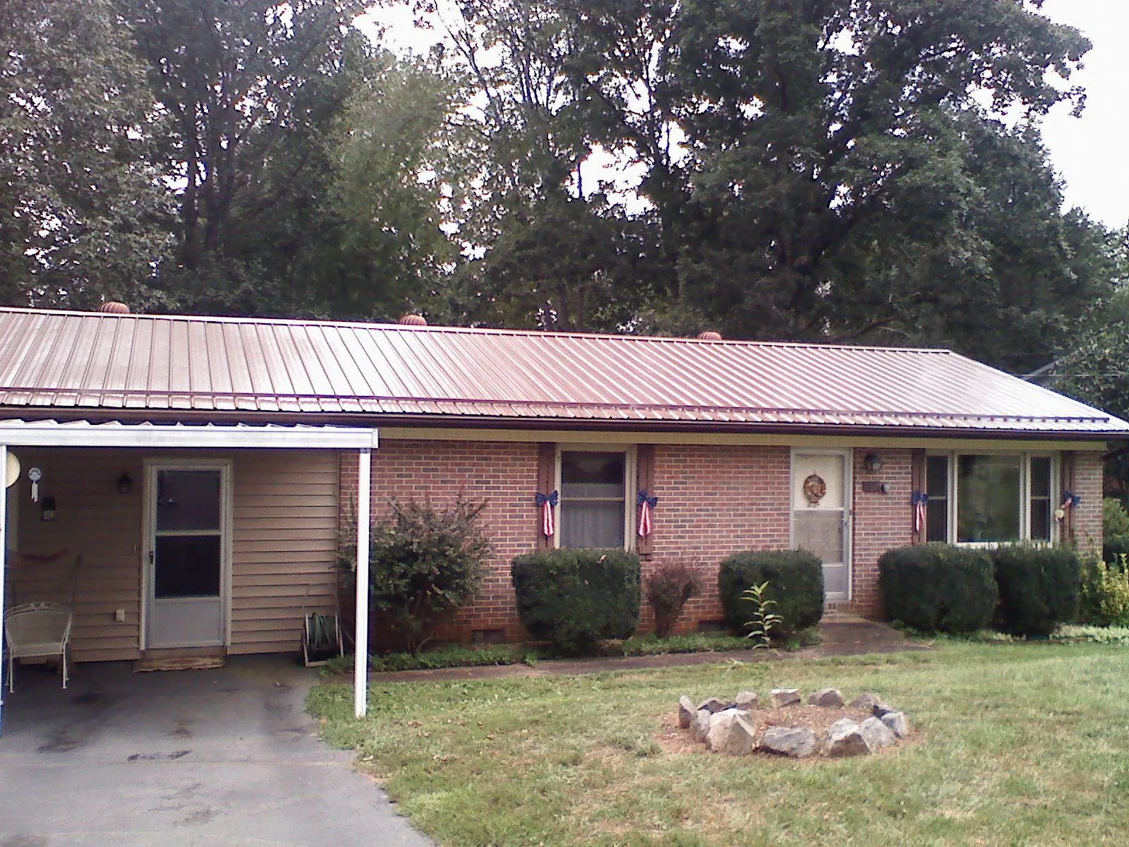 Bronze metal roof and carport on a brick ranch home — Roof Repair work by our crew in East Templeton